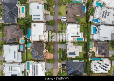 Aerial top down view of a suburban street lined with modern prestige homes with pools and rooftop solar in outer Sydney, Australia. Stock Photo