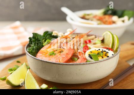 Delicious ramen with shrimps and egg in bowl on table, closeup. Noodle soup Stock Photo