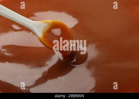 Taking tasty salted caramel with spoon, closeup. Space for text Stock Photo