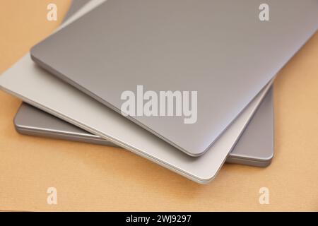 Different modern laptops on brown background, closeup Stock Photo