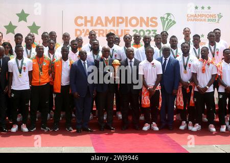 Abidjan, Cote d'Ivoire. 13th Feb, 2024. President of the Ivorian Football Federation Yacine Idriss Diallo (6th L, front row), holding the Africa Cup of Nations trophy, poses with President of Cote d'Ivoire Alassane Ouattara (6th R, front row) and members of the Cote d'Ivoire national football team during a ceremony awarding the Cote d'Ivoire national football team at the Presidential Palace in Abidjan, Cote d'Ivoire, Feb. 13, 2024. Cote d'Ivoire won the 2023 Africa Cup of Nations (AFCON) on Sunday in Abidjan, beating Nigeria 2-1 in the final. Credit: Zhang Jian/Xinhua/Alamy Live News Stock Photo