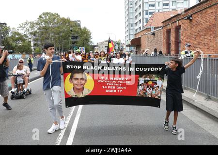 Sydney, Australia. 14 February 2024. Supporters assembled in Waterloo Green (TJ Hickey Park) in Waterloo on the twentieth anniversary of the death of Thomas ‘TJ’ Hickey. The death of the 17-year-old Aboriginal boy sparked the Redfern riots. Protesters blame the police for his death. They marched from Waterloo Green (TJ Hickey Park) next to the Waterloo public housing block where the incident happened to the Redfern police station and onto the Redfern Community Centre on Hugo Street. Credit: Richard Milnes/Alamy Live News Stock Photo