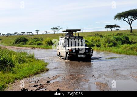 Pulling a stuck safari jeep in a muddy river in the Serengeti National Park in Tanzania. Stock Photo