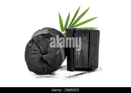 Natural charcoal with bamboo leaves on white background. Stock Photo