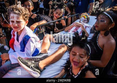 Barranquilla, Colombia. 13th Feb, 2024. A group of children are performing the Joselito funeral. On the last day of the Barranquilla Carnival, Joseilito, the soul of the Carnival die. The parade is made by Queen of the Carnival and citizens, who organized in different groups are performing the Joselito funeral and his widows, carries Joselito's coffins and crying for him during the parade. Credit: SOPA Images Limited/Alamy Live News Stock Photo