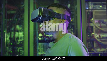 Image of data processing, african american male it engineer in vr goggles and computer servers Stock Photo