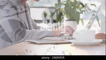Two men work on a laptop with graphs, facing each other in a digital composite. Stock Photo
