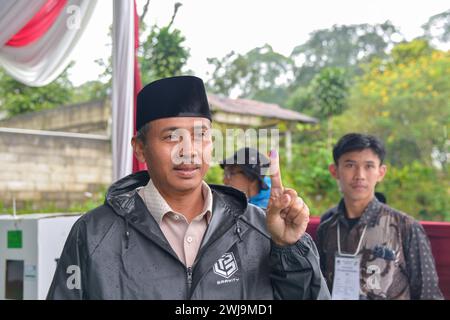 Bogor, Indonesia. 14th Feb, 2024. A voter shows his finger after casting his ballot at the No. 35 polling station in Bogor, Indonesia, Feb. 14, 2024. Voting for Indonesia's general elections officially began Wednesday morning, according to the country's General Elections Commission (KPU). Credit: Xu Qin/Xinhua/Alamy Live News Stock Photo