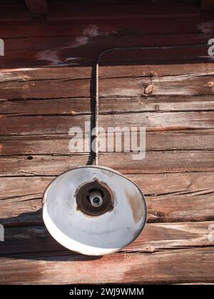 old lamp without bulb on wooden log wall exterior Stock Photo