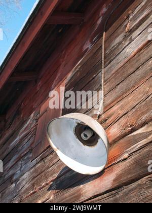 old lamp without bulb on wooden log wall exterior Stock Photo