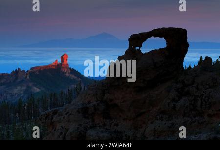 Dramatic dawn light illuminates rock formations above a sea of clouds Stock Photo