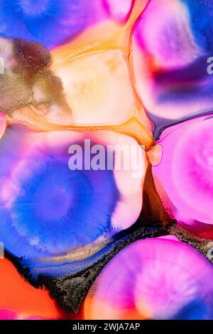 A vibrant blend of abstract ink patterns in water creating a mesmerizing fluid art composition with vivid colors. Stock Photo