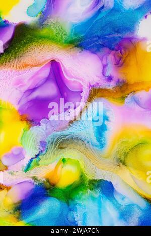 Abstract fluid art with vibrant swirls of yellow, blue, purple, and green creating a dreamy background Stock Photo