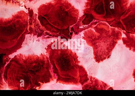 Vibrant abstract texture resembling marble with swirling patterns of red and pink hues, perfect for backgrounds and designs Stock Photo