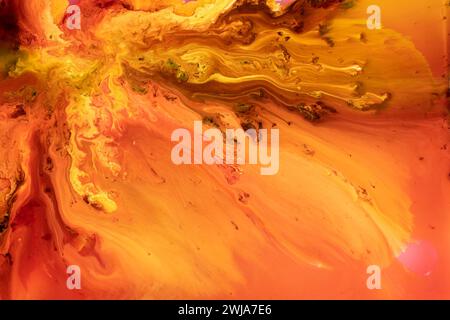 An abstract image showcasing fluid, marble-like textures in warm, vibrant colors ranging from yellow to red Stock Photo