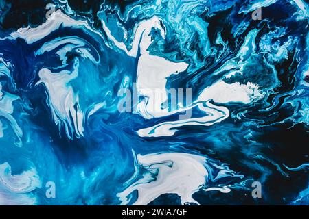An abstract fluid art painting featuring swirling shades of blue and white, creating a marble-like texture Stock Photo