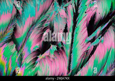 An electrifying abstract pattern featuring the vibrant hues of pink and green crystals under magnification Stock Photo