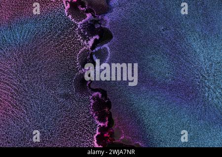 Close-up of a vibrant purple and blue glitter texture with a sparkling surface creating an abstract background Stock Photo