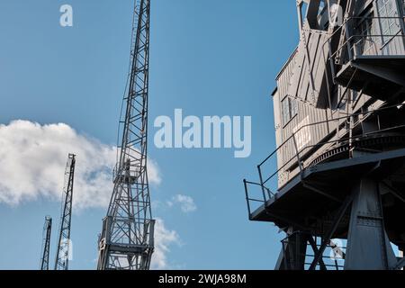 Old disused dockyard cranes on Princes Wharf, Spike Island, Bristol docks, against a blue sky Stock Photo