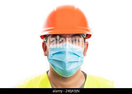 Close-up of adult constructor man in orange safety hardhat work attire wearing disposable surgical or medical mask to prevent sars covid19 influenza v Stock Photo
