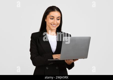Happy young businesswoman using laptop computer Stock Photo