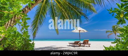 Amazing beach. Romantic chairs umbrella panoramic sandy beach palm leaves, sun sea sky. Summer holiday couples vacation. Love happy tropical landscape Stock Photo