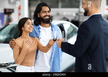 Manager Man Giving New Auto Key To Young Indian Family Stock Photo