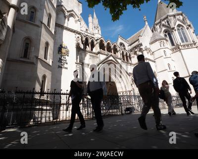 Pedestrians walking past the Royal Courts of  Justice in London UK Stock Photo