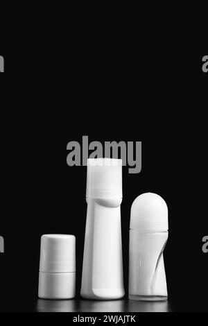 Set of white antiperspirant deodorant roll-on, isolated on black background, mockups of white plastic packaging for personal hygiene, containers Stock Photo