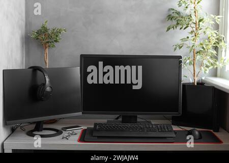 The workplace of the programmer in the apartment. Design of a loggia with a freelancer's workplace, monitors on the table, a computer in a modern Stock Photo