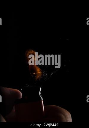 Hand with lighter igniting sparks Stock Photo