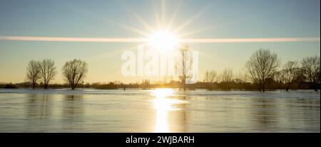 Super wide angle view of bench on the edge of high water level river IJssel boulevard of tower town Zutphen with steel draw bridge in the background Stock Photo