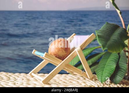 Easter egg on sunny sea beach vacation sit on sun lounger sun bathing, concept of Easter holiday vacation. Stock Photo