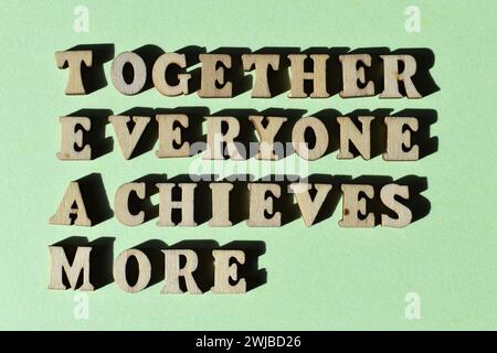 TEAM acronym for Together Everyone Achieves More in wooden alphabet letters isolated on green background Stock Photo