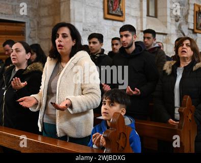 Bethlehem, West Bank. 14th Feb, 2024. Palestinian Catholics pray during Ash Wednesday mass, the first day of Lent, in St. Catherine's Church in Bethlehem, West Bank, on Wednesday, February 14, 2024. Ash Wednesday marks the countdown to Easter with prayer, fasting and vowing devotion to God. Photo by Debbie Hill/ Credit: UPI/Alamy Live News Stock Photo