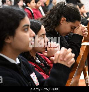 Bethlehem, West Bank. 14th Feb, 2024. PalestinianC atholic schoolgirls pray during Ash Wednesday mass, the first day of Lent, in St. Catherine's Church in Bethlehem, West Bank, on Wednesday, February 14, 2024. Ash Wednesday marks the countdown to Easter with prayer, fasting and vowing devotion to God. Photo by Debbie Hill/ Credit: UPI/Alamy Live News Stock Photo