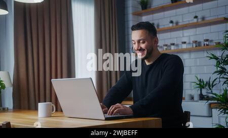 Man representative call center agent in wireless headset helping client with complaints using laptop. Male Operator working at home in kitchen, custom Stock Photo