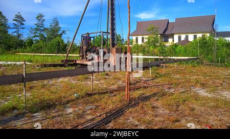 strong hydraulic hammer for pressing piles in construction site Stock Photo