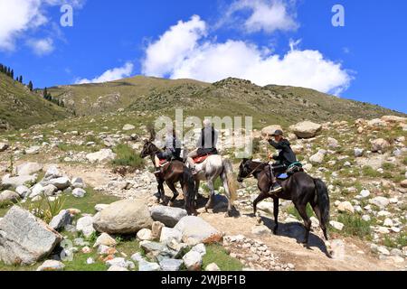 August 31 2023 - Semyonovka, Kyrchyn Valley in Kyrgyzstan: People riding horses in north of Kyrgyzstan mountains Stock Photo