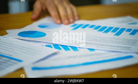 Business people analyzing charts information on documents, using papers to create report analysis, team working on statistical data Stock Photo