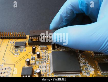 Removing an Integrated Circuit (IC) from the dip socket.   Semiconductor components on the electronic board. Stock Photo