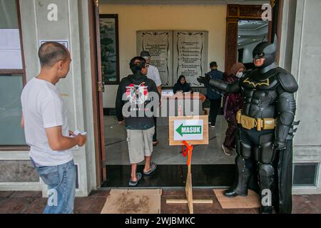Bogor, Indonesia. 14th Feb, 2024. An election official wearing Batman superhero costume stand guard during Indonesia presidential and legislative elections at a polling station in Bogor, Indonesia on February 14, 2024. (Photo by Andi M Ridwan/INA Photo Agency/Sipa USA) Credit: Sipa USA/Alamy Live News Stock Photo
