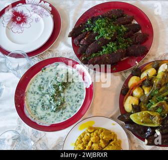 A variety of vegetarian dishes on the plates on the table. Stock Photo