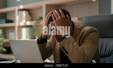 African American man exhausted businessman overworked online job on laptop business problem trouble bad result crash failure difficulties stress Stock Photo