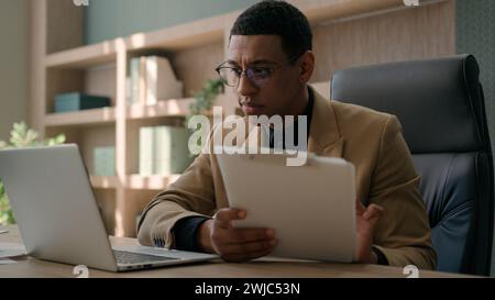 Business man African American accountant male office worker write financial data analysis plan strategy focused businessman work with laptop computer Stock Photo