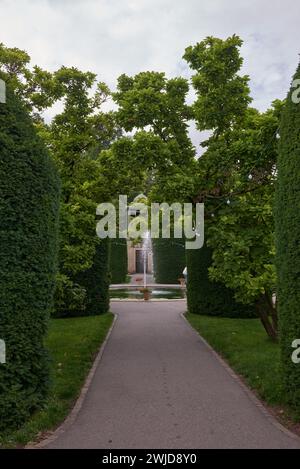 Tranquil Park Oasis: Fountain Amidst Scenic Landscapes. Urban Oasis- Majestic Fountain Amidst Lush Parkland. Splendid Fountain Gracing City Park Stock Photo