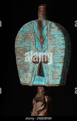 Close up of a wooden Kota reliquary figure from Gabon, isolated on a black background. Tribal African art, showcasing masterful craftsmanship and spir Stock Photo