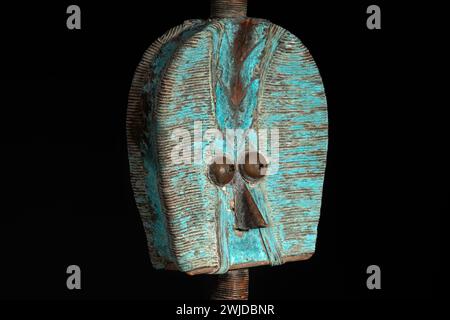 Close up of a wooden Kota reliquary figure from Gabon, isolated on a black background. Tribal African art, showcasing masterful craftsmanship and spir Stock Photo