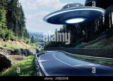 Alien spaceship flying over road in mountains. UFO Stock Photo