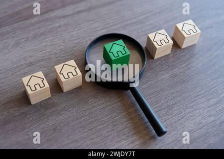 Wooden blocks with house icon and magnifying glass. Choose and buying a right house concept. Stock Photo